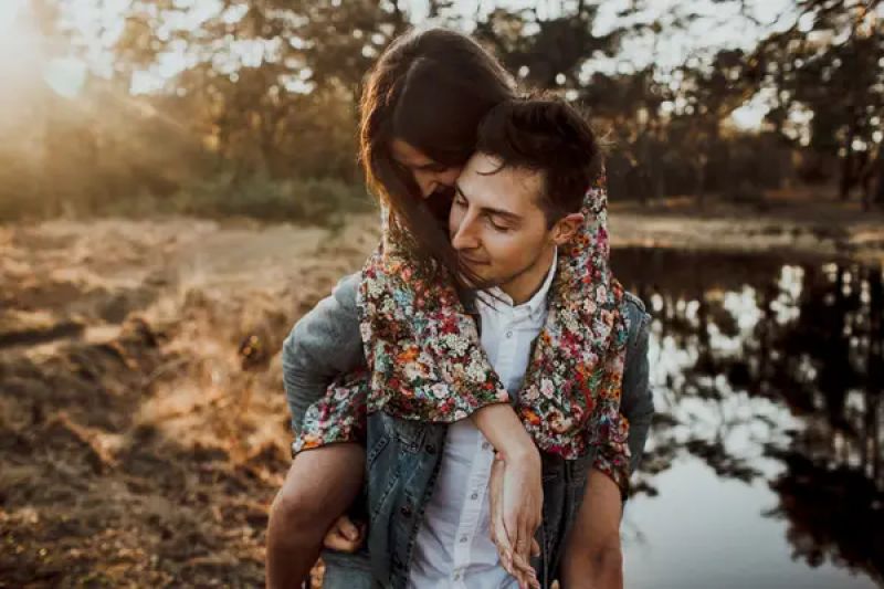 Der Mann hat seine Liebste Huckepack genommen, sie schmiegt sich ganz innig an ihn. Dieser Platz eignet sich hervorragend für ein magisches Elopement, speziell zum Sonnenuntergang.